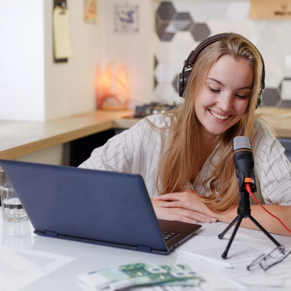 Blonde woman wearing headphones with microphone learning online training class
