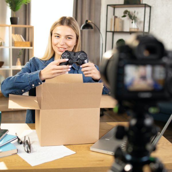 Woman recording video while unpacking box with joystick